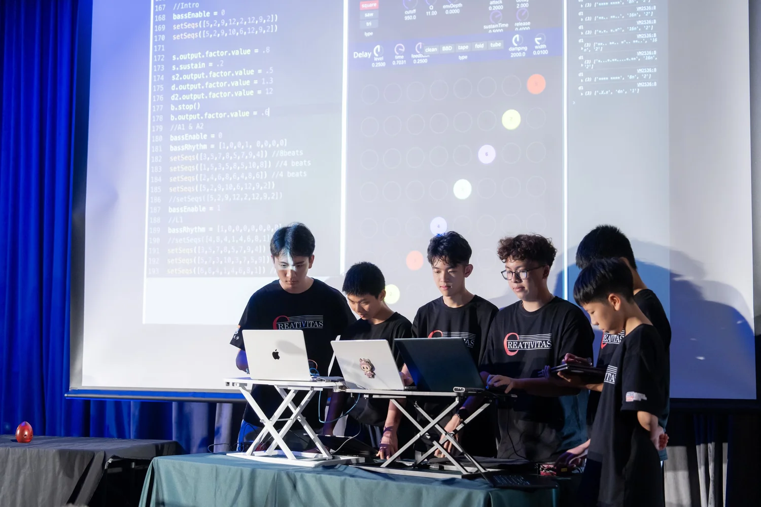 Students performing with laptops on stage