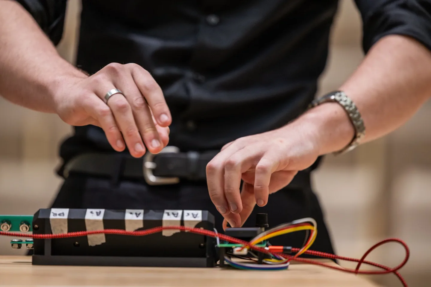 Hands playing a student-built electronic musical instrument